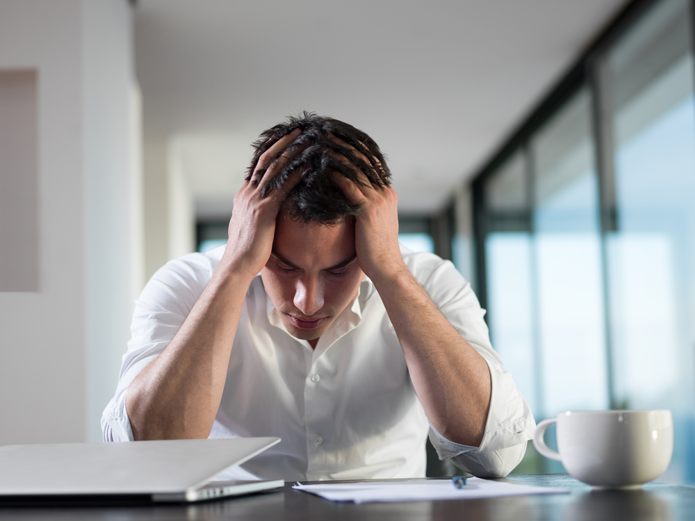 Man stressed, head in hands